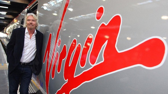 Richard Branson leaning against a Virgin Train.