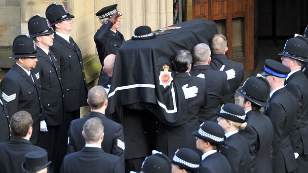 Greater Manchester Police Chief Constable, Sir Peter Fahy, salutes as the coffin is taken into Manchester Cathedral