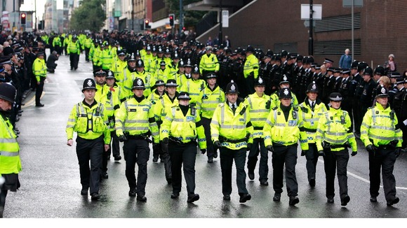 Police officers march along Deansgate 