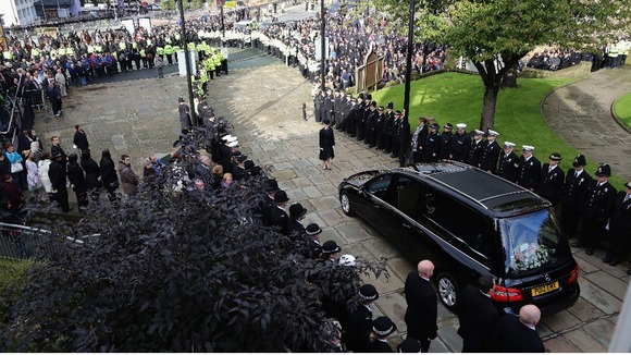 Line of police watch the funeral cortege of PC Fiona Bone