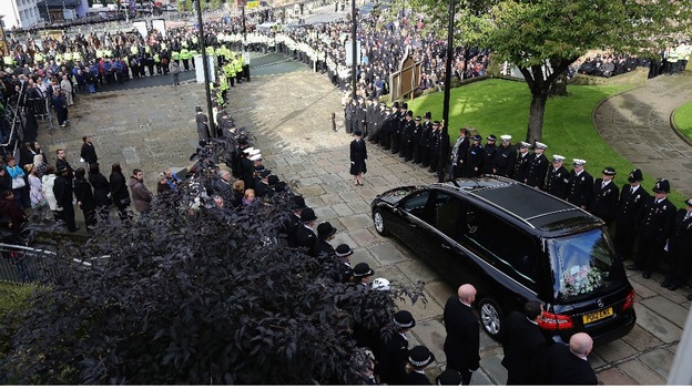 Line of police watch the funeral cortege of PC Fiona Bone