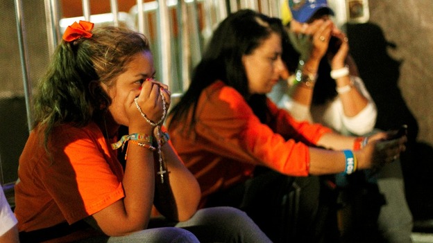 Crestfallen supporters of the opposition candidate Henrique Capriles