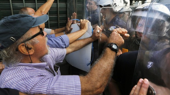 Pensioners push riot police during scuffles near the EU offices in Athens ahead of Merkel's visit