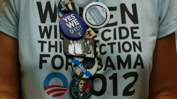 A supporter of President Obama wears a collection of badges during an election campaign rally in Colorado Springs