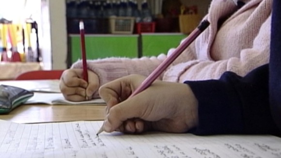 Children writing in a classroom.