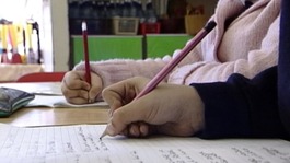 Children writing in a classroom.
