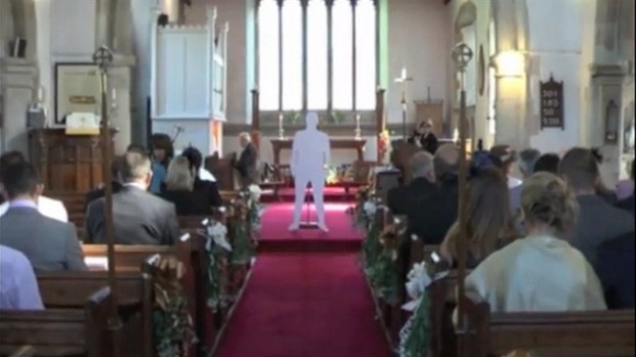 A cardboard cut-out of a vicar standing in the middle of the church.