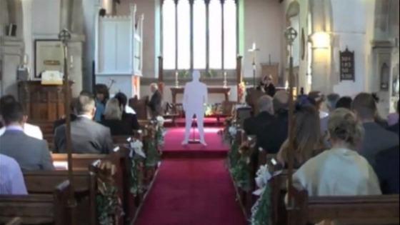 A cardboard cut-out of a vicar standing in the middle of the church.