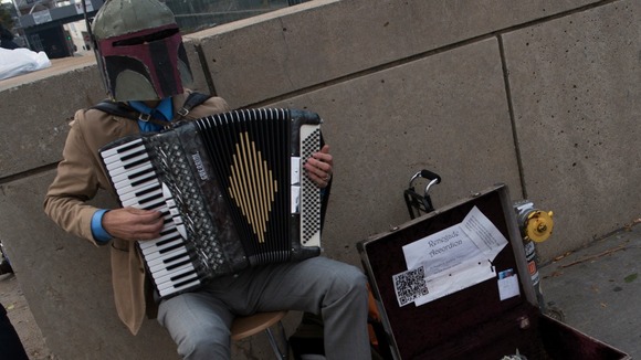 A participant dressed as Star Wars character Boba Fett plays the accordion during Comic Con.