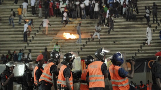 Senegalese football fans throw rocks at police.