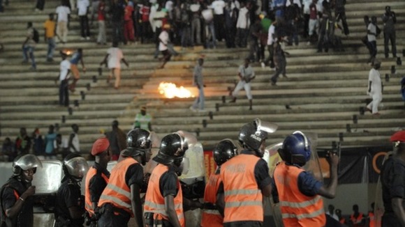 Senegalese football fans throw rocks at police.