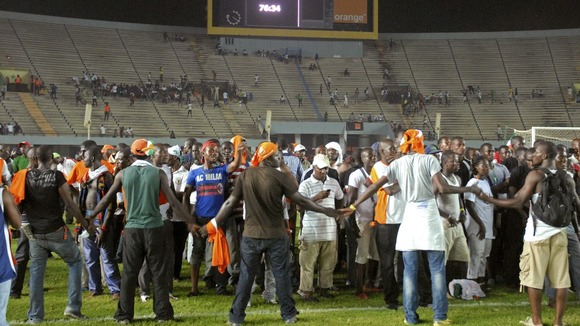 Fans of Ivory Coast's national football team help other fans escape the violence in the Leopold Sedar Senghor stadium in Dakar.