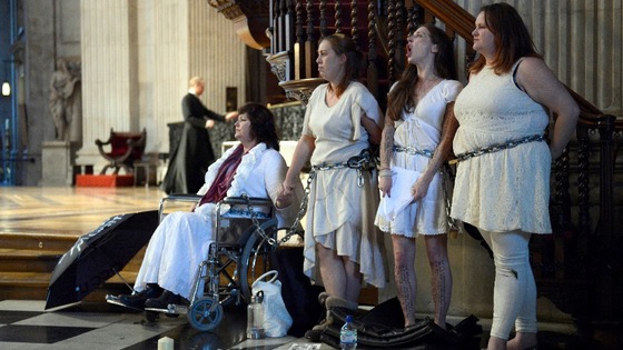 Female activists from the Occupy movement stage a protest by chaining themselves to the pulpit in St. Paul's Cathedral.