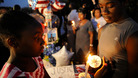 A teenager lights a candle during a vigil for Trayvon Martin in Sanford
