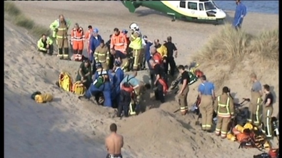 Emergency services try to hold back sand