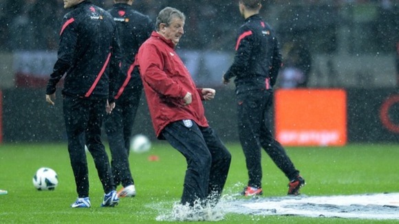 England boss Roy Hodgson tests the waterlogged pitch