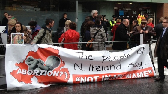 Protesters hold a banner outside the new clinic in Belfast
