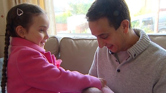 Dan and Angela's five-year-old daughter Lily helps dress the twins