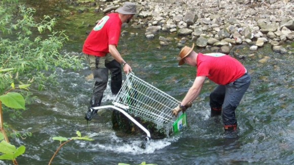 Workers clearing trolleys from river