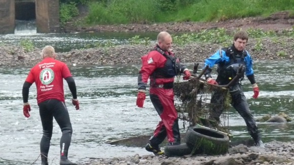 Workers clearing trolleys from river