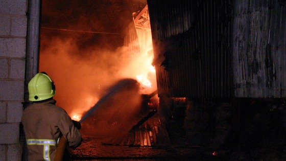 Fireman sprays water on the barn fire