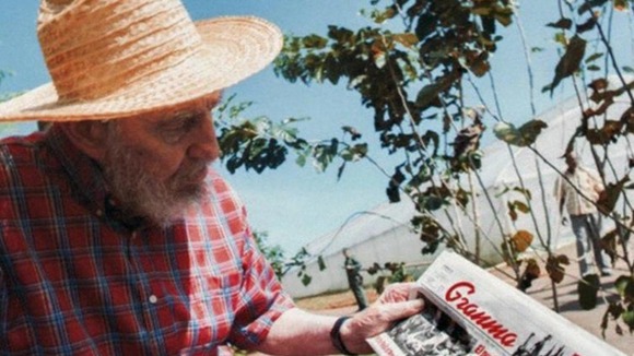Castro is seen reading the Communist Party newspaper Granna