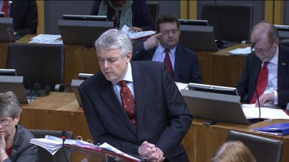 First Minister Carwyn Jones leaning on the lecturn