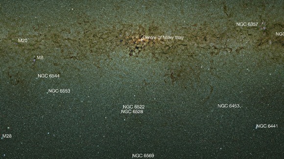 An infrared view of the Milky Way bulge that is labelled to show a selection of the many nebulae and clusters in this part of the sky.