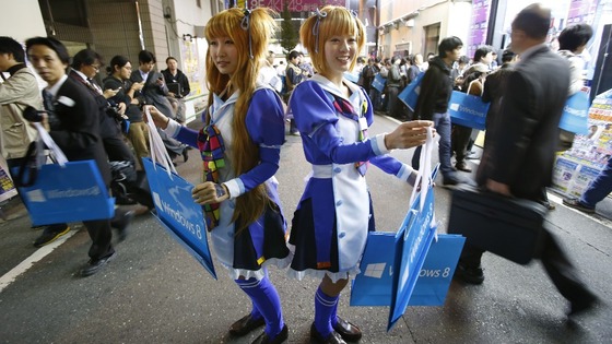  Women wearing cosplay outfits distribute paper bags promoting Windows 8 