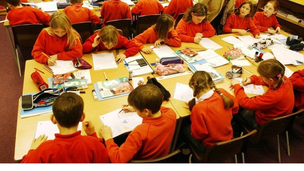 Qualified teacher helping pupils in a lesson