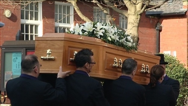 Pallbearers carry the coffin