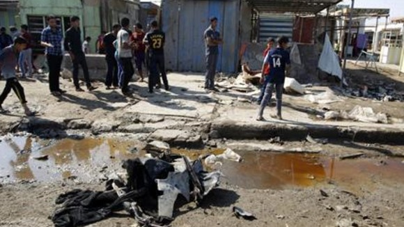 Residents inspect the aftermath of the bomb in Baghdad.