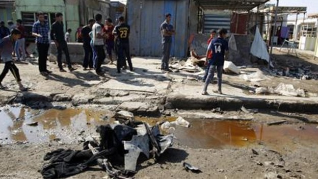 Residents inspect the aftermath of the bomb in Baghdad.