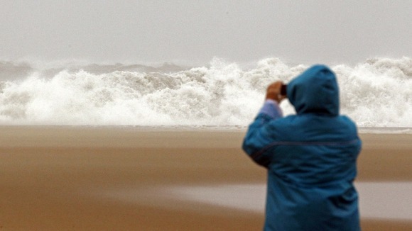 A woman photographs waves from the Atlantic Ocean in Ocean City, Maryland.