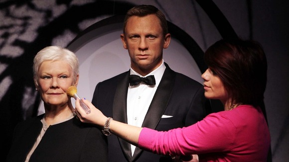 Final touches to the wax works of Daniel Craig and Judi Dench