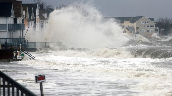 Waves crash over homes along the shoreline in Milford, Connecticut