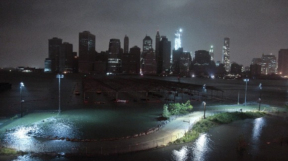 A car drives through water driven onto a roadway by Hurricane Sandy in Southampton, New York