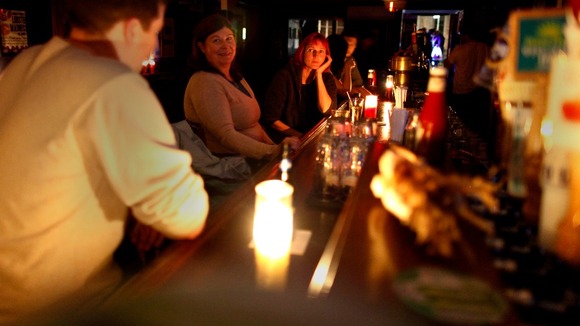 Patrons drink at a bar and use only candlelight in the aftermath of Hurricane Sandy in New York.