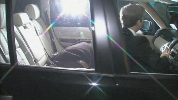 Freddie Starr is seen covered in the back of a car as it arrives at his home