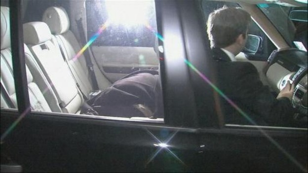Freddie Starr is seen covered in the back of a car as it arrives at his home