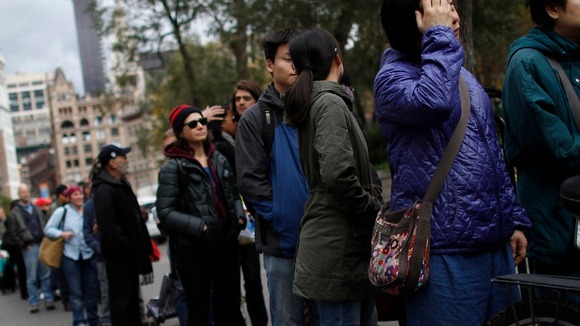 People queue for a bag of dry ice in Union Square in the aftermath of Superstorm Sandy in New York.
