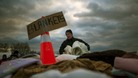 A victim of hurricane Sandy takes blankets from a aid distribution site in the Staten Island