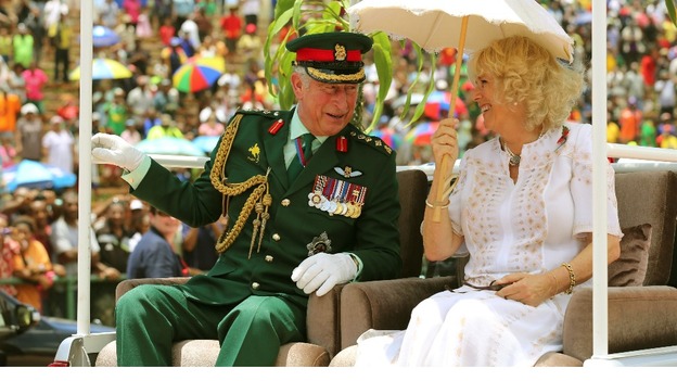 The Prince of Wales and Duchess of Cornwall are driven on the back of a truck visit