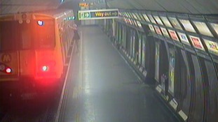 Georgia leans against the train as the guard signals the train is safe to move.