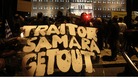 A protester holds a banner reading "Traitor Samara get out"(Greece's Prime Minister Antonis Samaras )in front of the parliament .