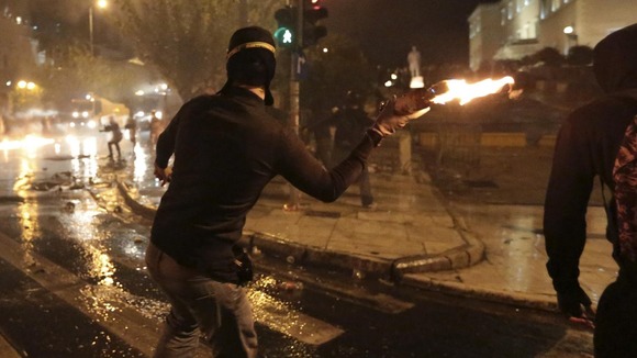 A protester throws a molotov cocktail at riot police during a 48-hour general strike in central Athens