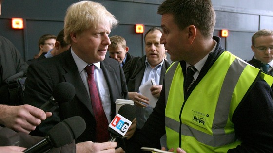Mayor of London Boris Johnson speaks with a representative from the Paddington taxi share scheme.