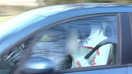 Bradley Wiggins gestures at the media as he travels back home.