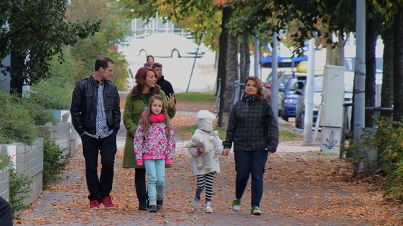 Reporter walks down the street with family in Finland