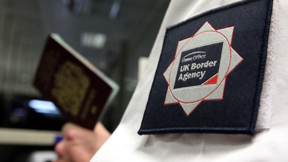 A UK Border Agency officer checking a passport in the North Terminal of Gatwick Airport, Sussex.
